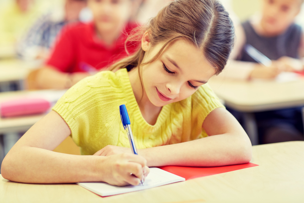 Girl writing in school desk