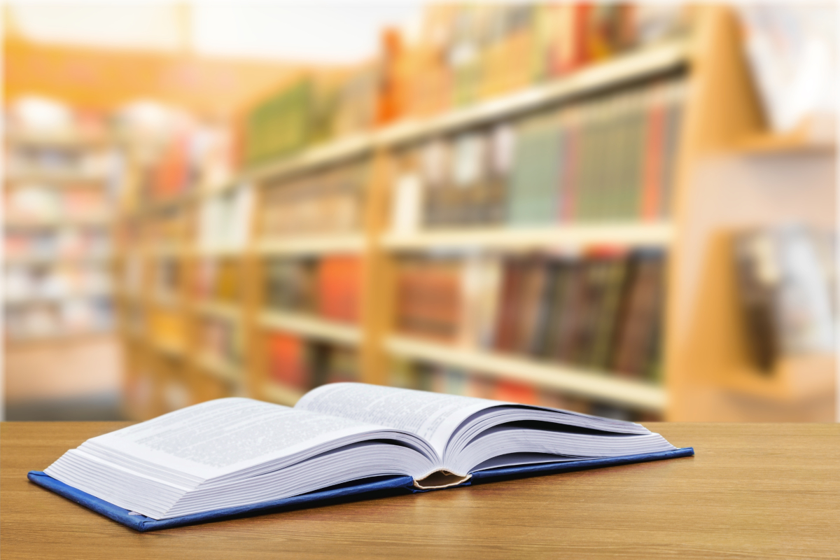 An open book laying on a desk in a libarary