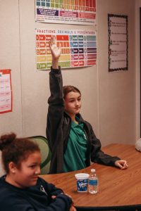 A girl raising her hand in class